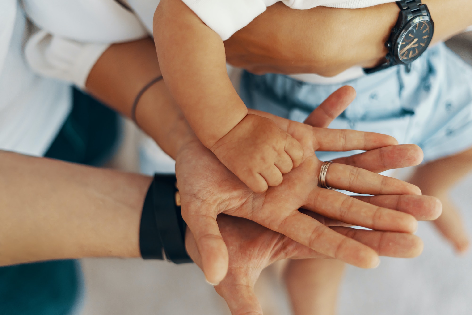 Mom and Dad hold baby's hand